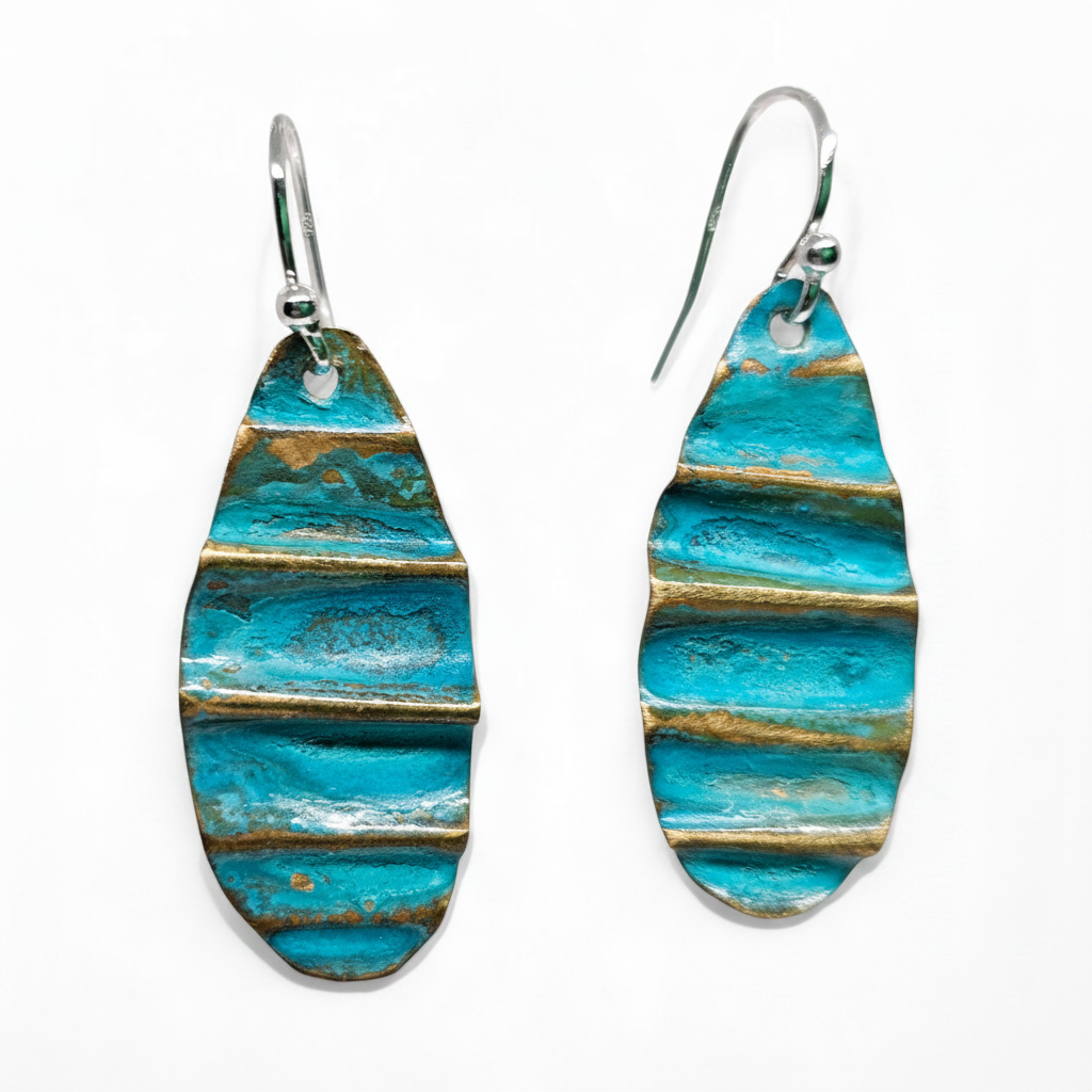Turquoise and gold patterned earrings on a white background