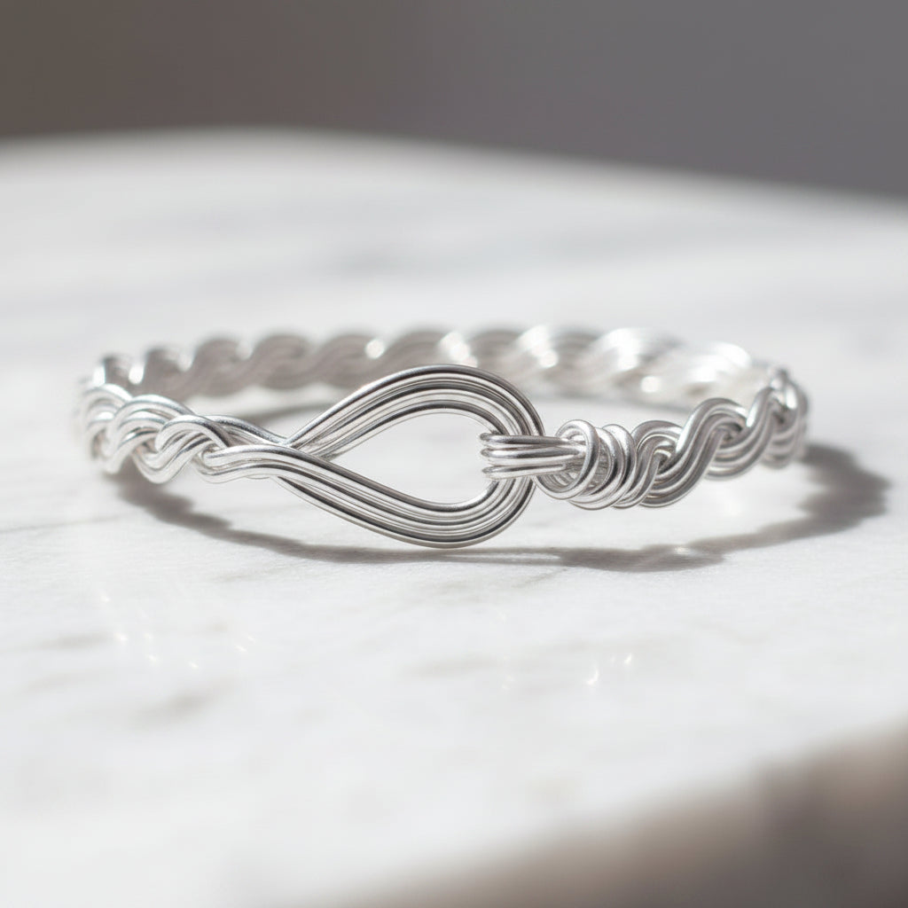 A handcrafted 14K gold-filled braided bracelet a marble surface