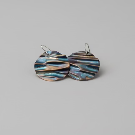 Round earring that are made from brass to mimic part of a scallop shell . with a two tone dark iridescent goldish coloring