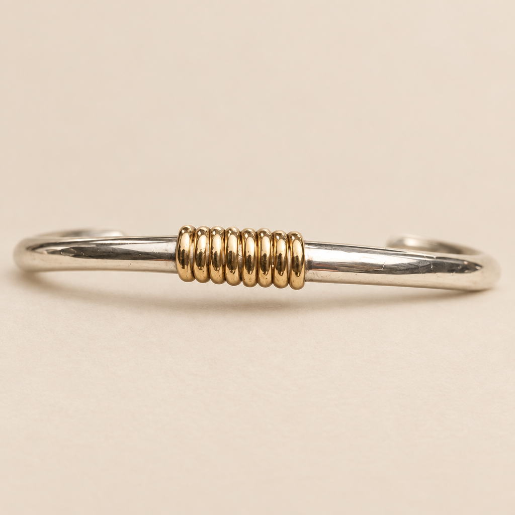 Meridian bracelet detail on a warm ivory studio background